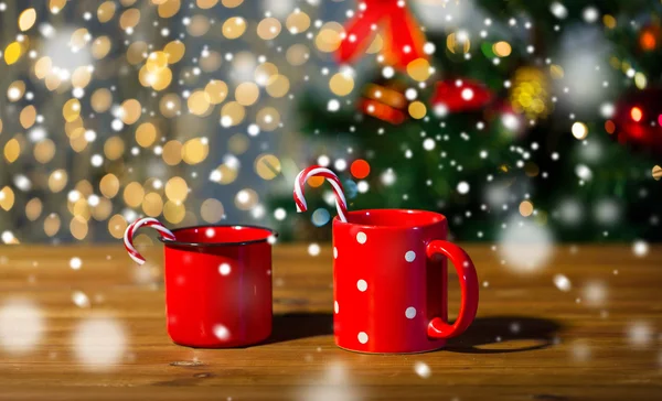 Boże Narodzenie candy laski i kubki na drewnianym stole — Zdjęcie stockowe