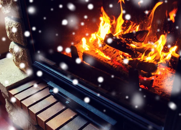 Close up of burning fireplace with snow — Stock Photo, Image