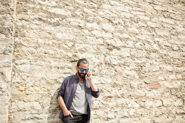 Uomo sorridente con smartphone che chiama in strada — Foto Stock