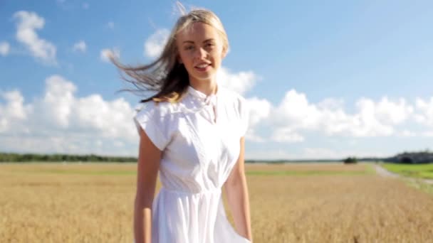 Sorrindo jovem mulher em vestido branco no campo de cereais — Vídeo de Stock