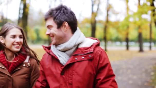 Feliz pareja joven caminando en el parque de otoño — Vídeo de stock