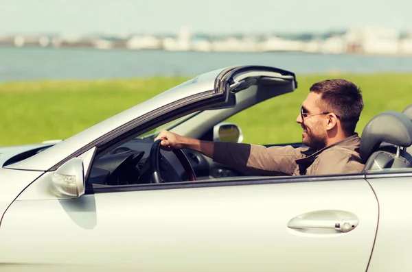 Homem feliz dirigindo carro cabriolet ao ar livre — Fotografia de Stock