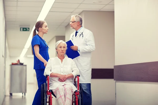 Médicos y mujeres mayores en silla de ruedas en el hospital — Foto de Stock