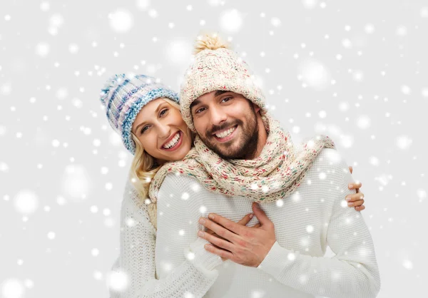 Sorridente coppia in inverno vestiti abbracciando sopra la neve — Foto Stock