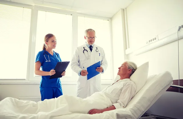 Arzt und Krankenschwester besuchen Seniorin im Krankenhaus — Stockfoto