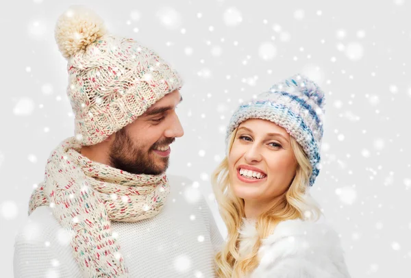 Smiling couple in winter clothes hugging over snow — Stock Photo, Image