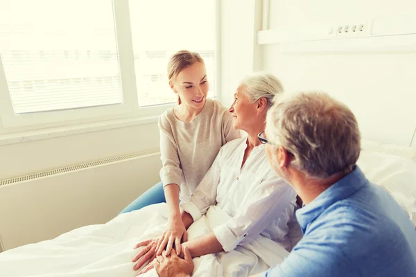 Šťastná rodina navštíví starší žena v nemocnici — Stock fotografie