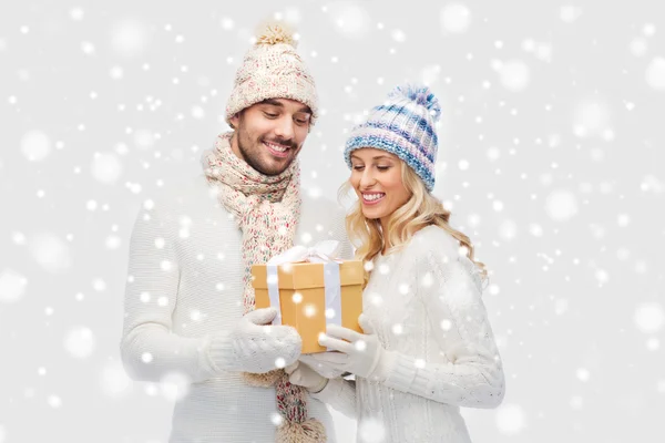 Pareja sonriente en ropa de invierno con caja de regalo —  Fotos de Stock