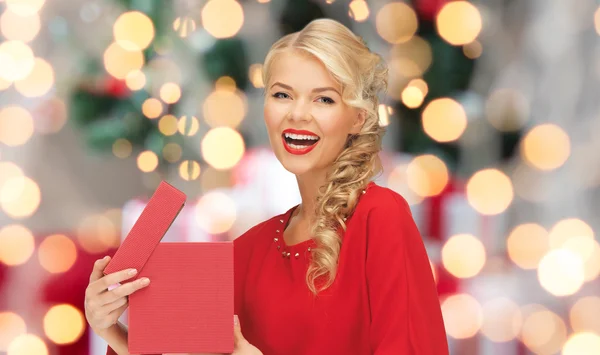 Glückliche Frau im roten Kleid mit Weihnachtsgeschenkschachtel — Stockfoto