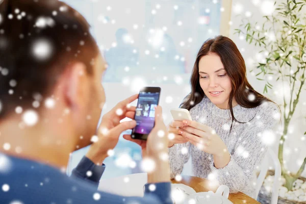 Glückliches Paar mit Smartphones trinkt Tee im Café — Stockfoto