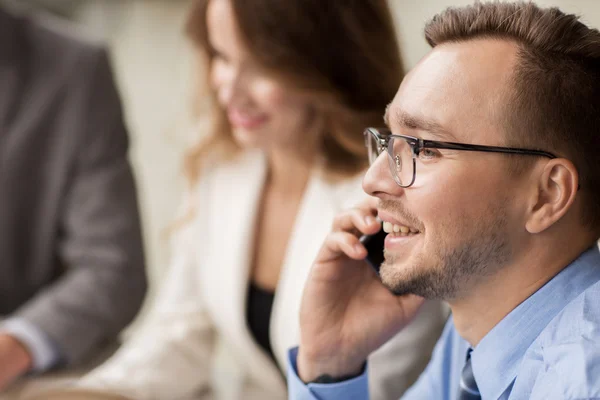 Businessman calling on smartphone at office — Stock Photo, Image