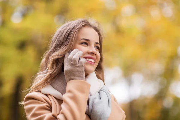 Kvinna ringer på smartphone i höst park — Stockfoto