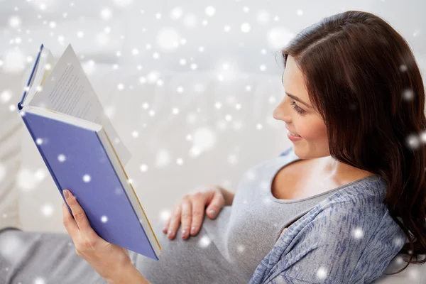 Feliz embarazada leyendo libro en casa — Foto de Stock