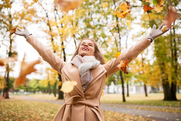 Boldog nő szórakozás levelekkel őszi parkban — Stock Fotó