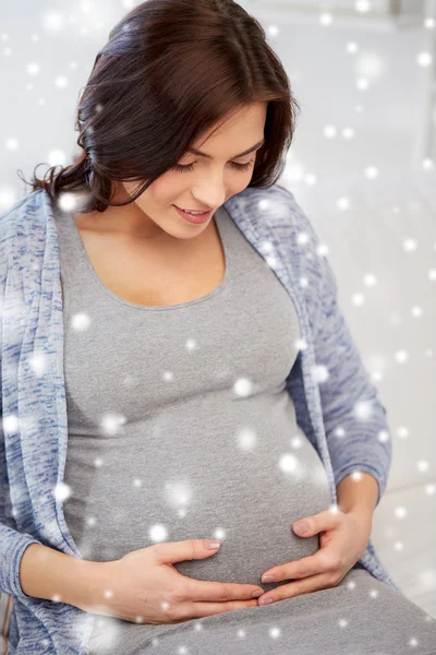 Happy pregnant woman sitting on sofa at home — Stock Photo, Image