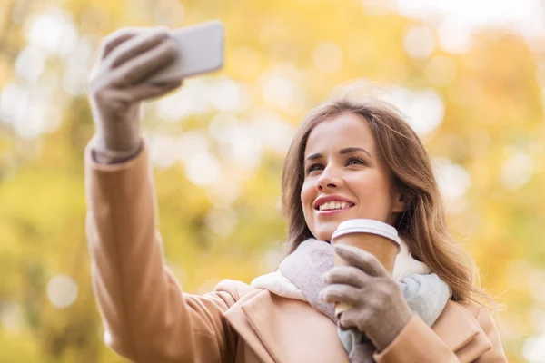 Kvinnan tar selfie av smartphone i höst park — Stockfoto