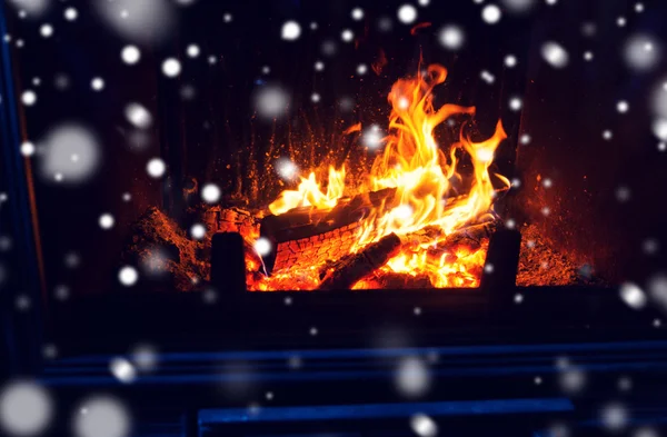 Close up of firewood burning in fireplace and snow — Stock Photo, Image