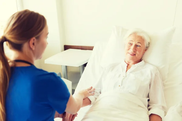Médico o enfermero que visita a una mujer mayor en el hospital —  Fotos de Stock