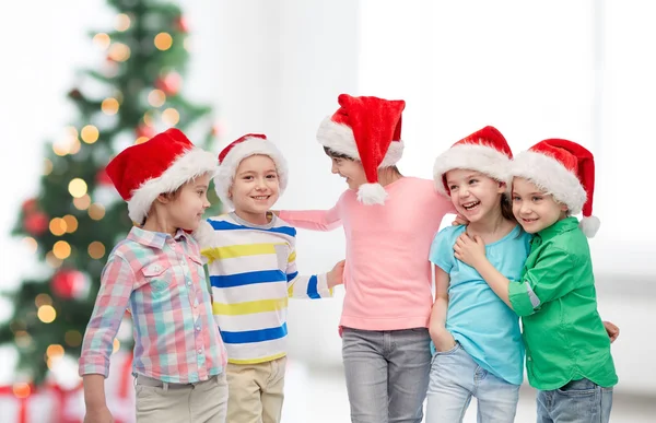 Glückliche kleine Kinder in Weihnachtsmützen — Stockfoto