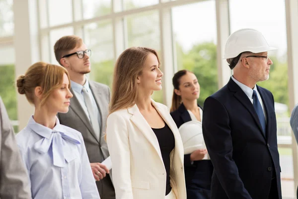 Business team in helmets walking along office — Stock Photo, Image