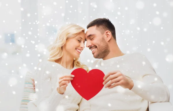 Casal feliz com coração vermelho abraçando em casa — Fotografia de Stock