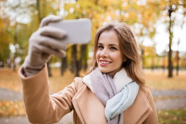 Kvinnan tar selfie av smartphone i höst park — Stockfoto