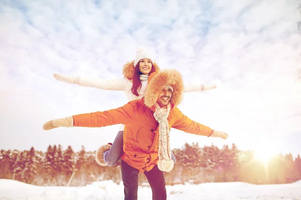 Couple heureux s'amuser sur fond d'hiver — Photo