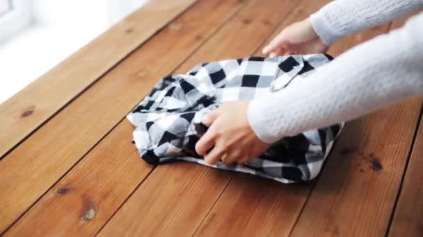 Frau faltet kariertes Hemd zu Hause auf Tisch — Stockvideo