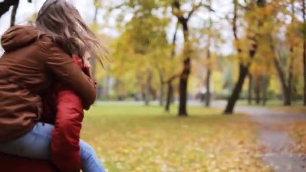 Feliz pareja joven divirtiéndose en el parque de otoño — Vídeo de stock