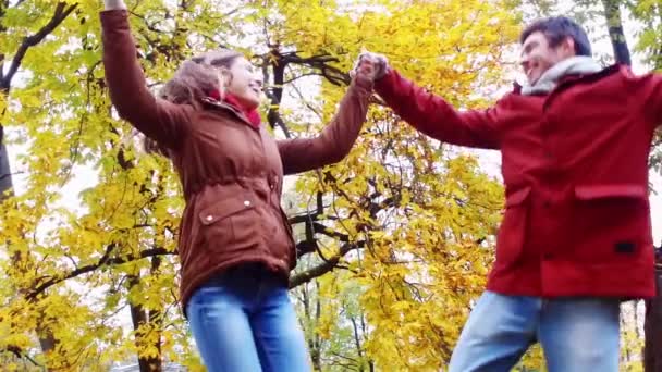Feliz jovem casal se divertindo no parque de outono — Vídeo de Stock