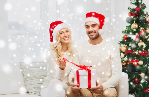 Щаслива пара вдома з різдвяною подарунковою коробкою — стокове фото