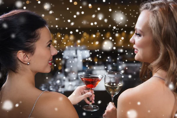 Mulheres felizes com bebidas no bar do clube noturno — Fotografia de Stock