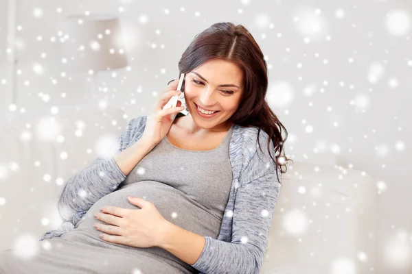 Счастливая беременная женщина звонит на смартфон дома — стоковое фото