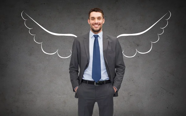 happy businessman with angel wings over gray