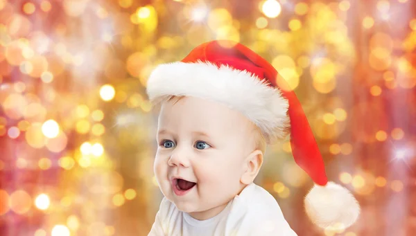 Малыш в рождественской шляпе Санты над синими огнями — стоковое фото