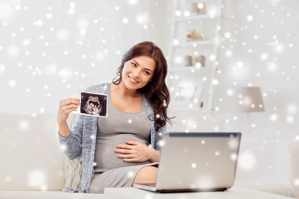 Mujer embarazada con imagen de ultrasonido y portátil — Foto de Stock