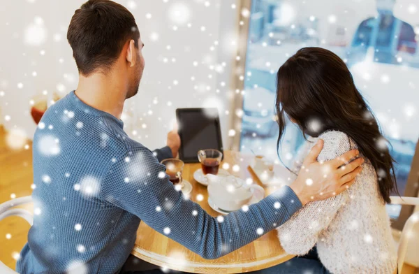 Happy couple with tablet pc drinking tea at cafe — Stock Photo, Image