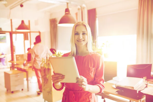 Gelukkig creatieve vrouwelijke beambte met tablet pc — Stockfoto