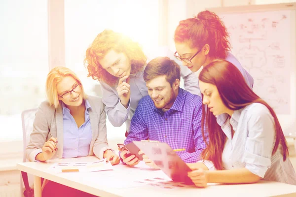 Equipo creativo con papeles y portapapeles en la oficina —  Fotos de Stock