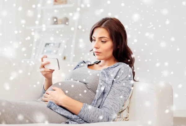 Femme enceinte triste avec smartphone à la maison — Photo