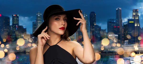 Красивая женщина в черной шляпе над городом Сингапур — стоковое фото