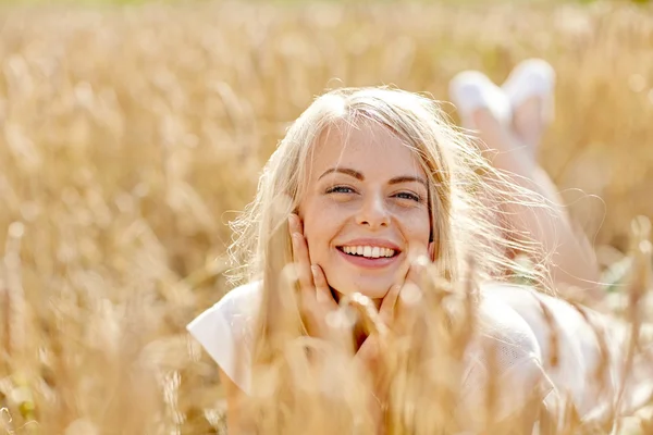 Gelukkig vrouw of tiener meisje liggen in cornflakes veld — Stockfoto