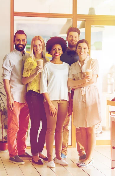 Lyckligt leende kreativa team med kaffe i office — Stockfoto