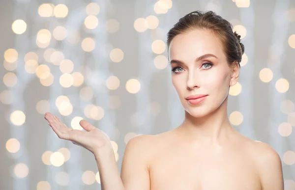 Mujer sosteniendo algo en su mano sobre las luces — Foto de Stock