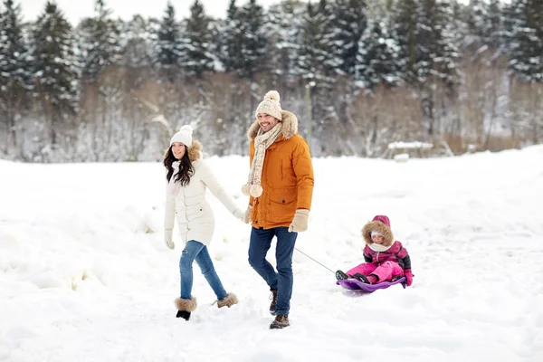 Família feliz com trenó andando na floresta de inverno — Fotografia de Stock