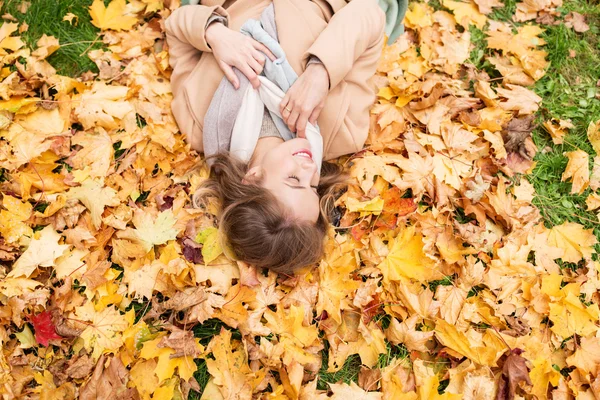 秋の葉の上に横たわる美しい幸せな女 — ストック写真