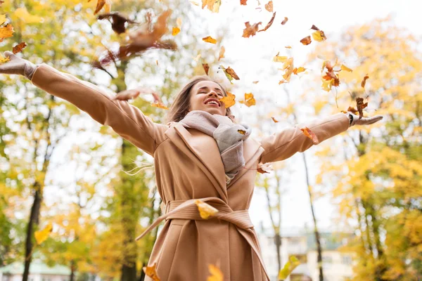 Gelukkig vrouw hebben plezier met bladeren in de herfst park — Stockfoto