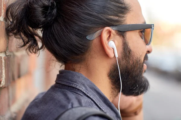 Close up of man with earphones listening to music — Stock Photo, Image