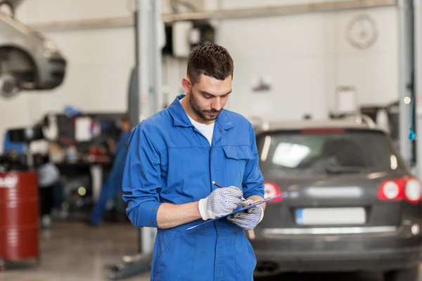 Mecánico de automóviles hombre con portapapeles en taller de coches — Foto de Stock