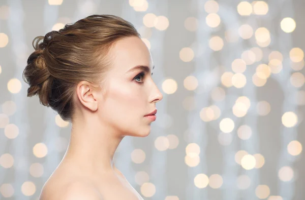 Vacker ung kvinna ansikte över helgdagar lampor — Stockfoto